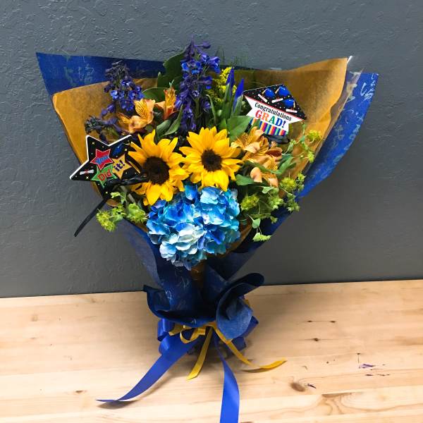 Bouquet of sunflowers, blue hydrangea, and purple flowers with graduation picks