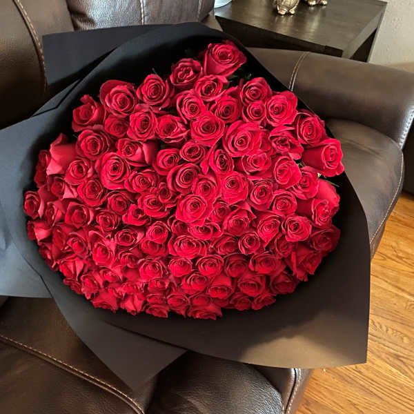 Large bouquet of red roses wrapped in black paper