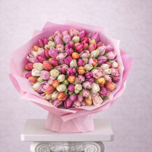 Bouquet of pink and white tulips wrapped in pink paper