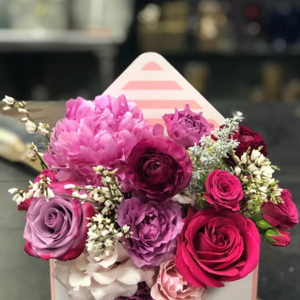 Pink and purple rose bouquet in a white gift box