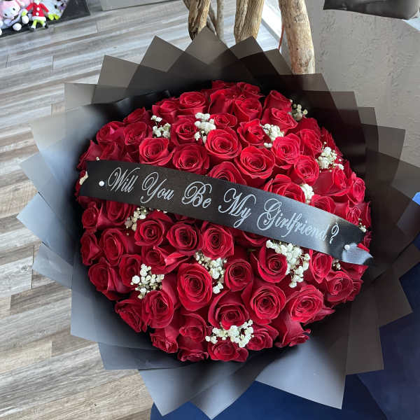Bouquet of red roses with a black ribbon banner