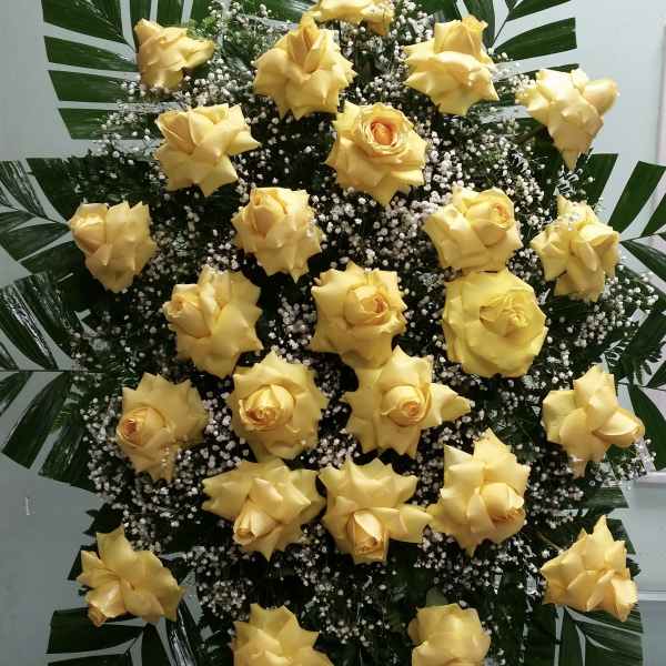 Large standing arrangement of yellow roses with white filler flowers