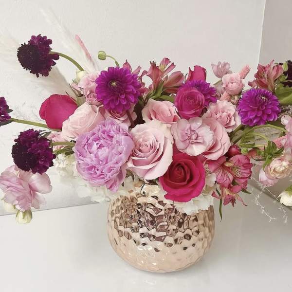 Pink and purple mixed bouquet in a textured glass vase