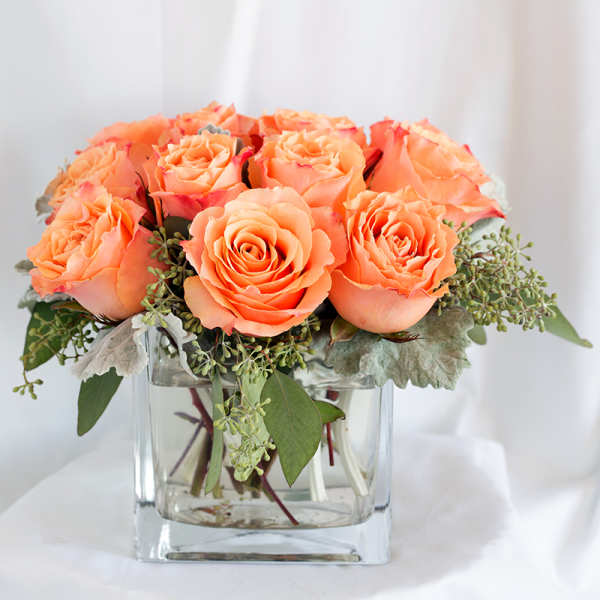 Peach roses arranged in a clear glass vase
