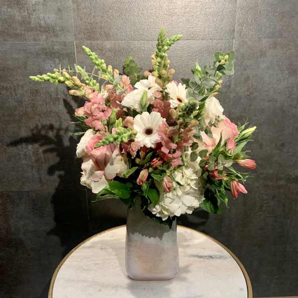 Pink and white mixed bouquet in a tall silver vase