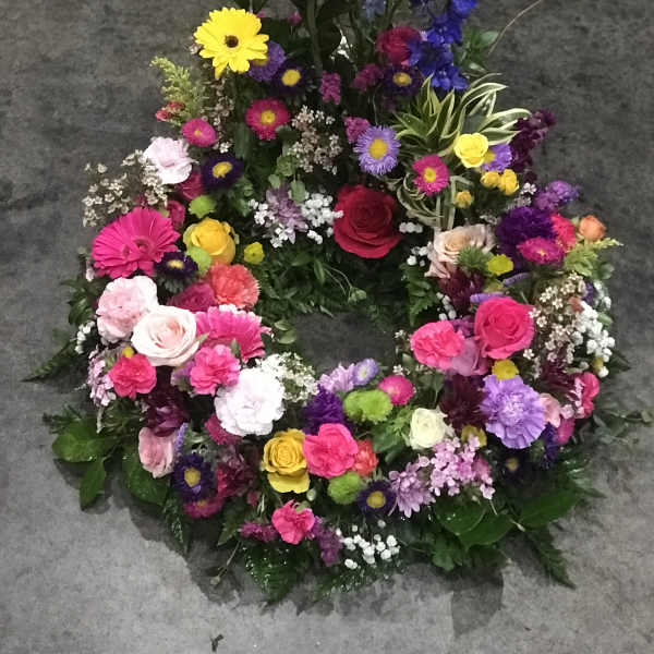 Colorful floral wreath with roses, daisies, and mixed blooms