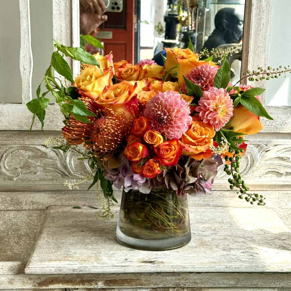 Orange and pink mixed bouquet in a glass vase