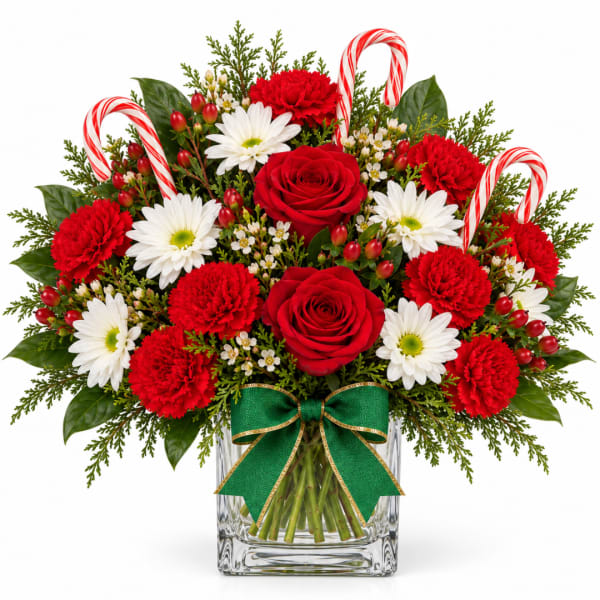 Red roses and carnations with white daisies in a glass vase with candy canes