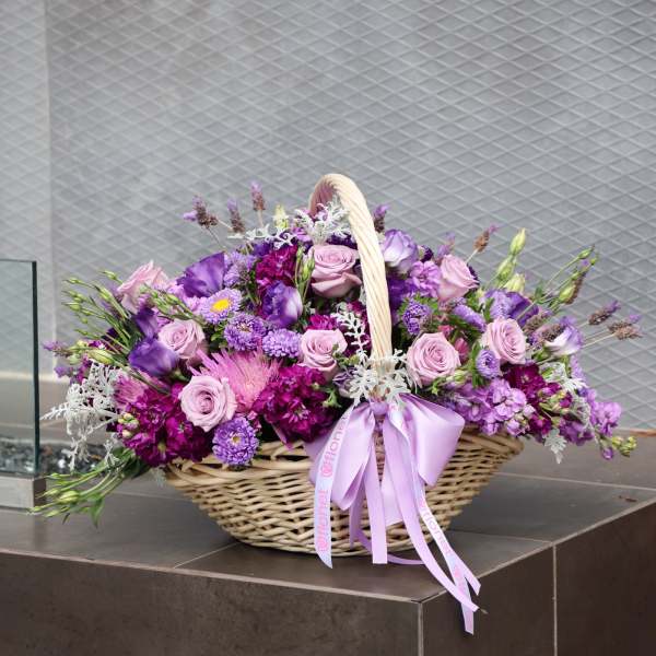 Basket of purple and pink flowers with a lavender ribbon