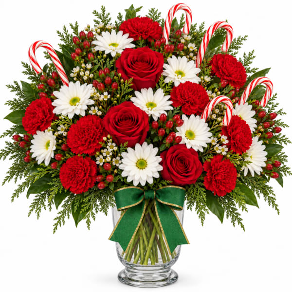 Red and white floral arrangement in a glass vase with candy canes
