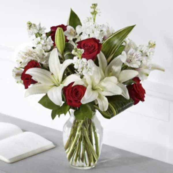 Red roses and white lilies in a clear glass vase