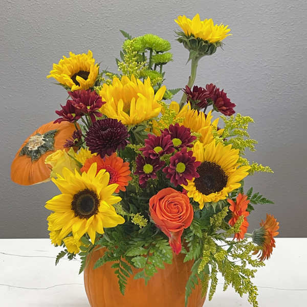 Sunflower and chrysanthemum arrangement in a pumpkin container