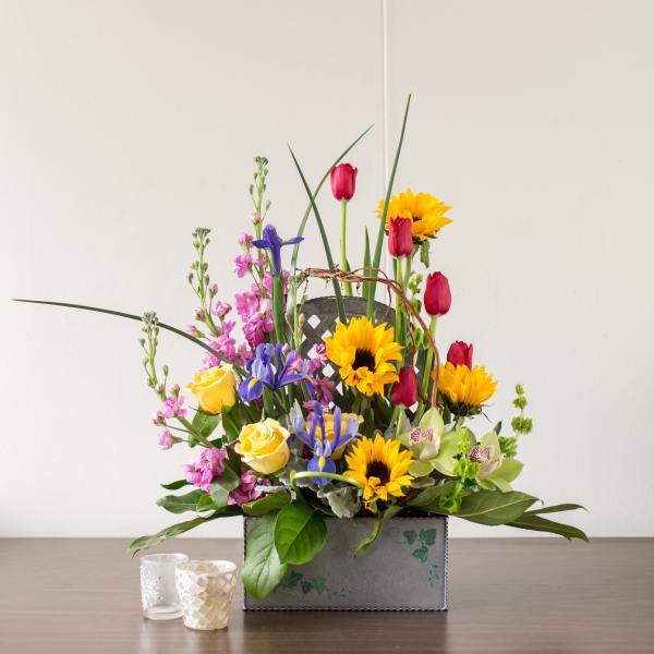 Mixed bouquet with sunflowers, roses, and irises in a decorative box