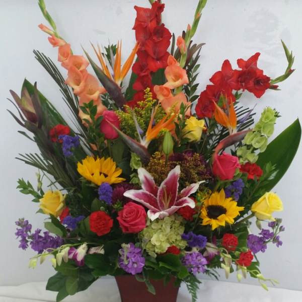 Tall mixed flower arrangement in a burgundy vase