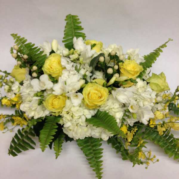 Yellow and white floral arrangement with fern fronds