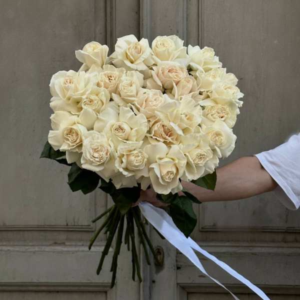 Bouquet of cream roses tied with a white ribbon