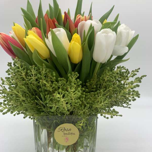 Bouquet of multicolored tulips in a clear glass vase