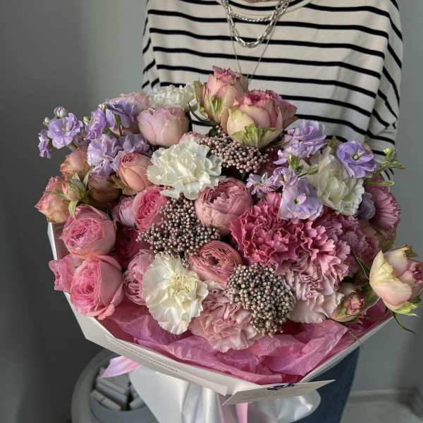 Large bouquet of pink and lavender flowers wrapped in white paper