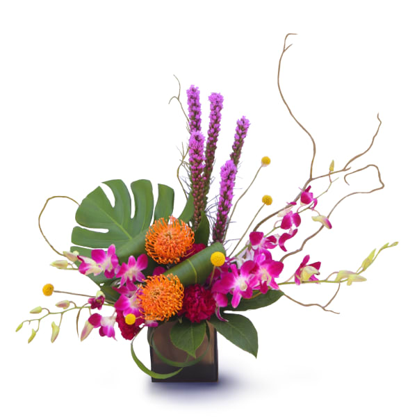 Tropical floral arrangement with pink orchids and orange blooms in a dark vase