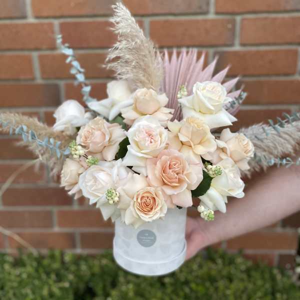 Bouquet of blush and white roses in a white hat box
