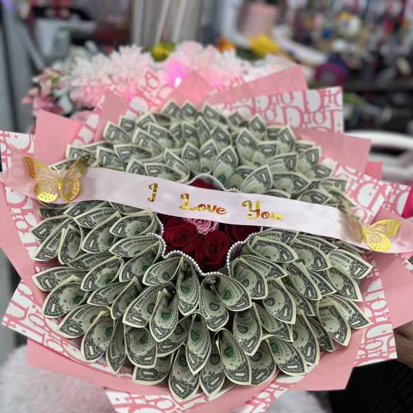 Bouquet made of folded dollar bills with red roses and pink ribbon