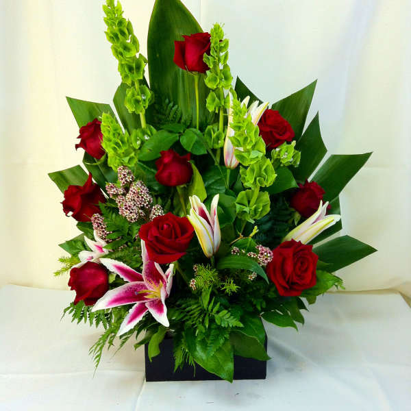 Red roses and pink lilies in a black rectangular vase