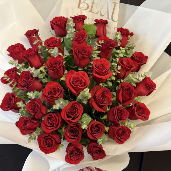 Bouquet of red roses wrapped in white paper