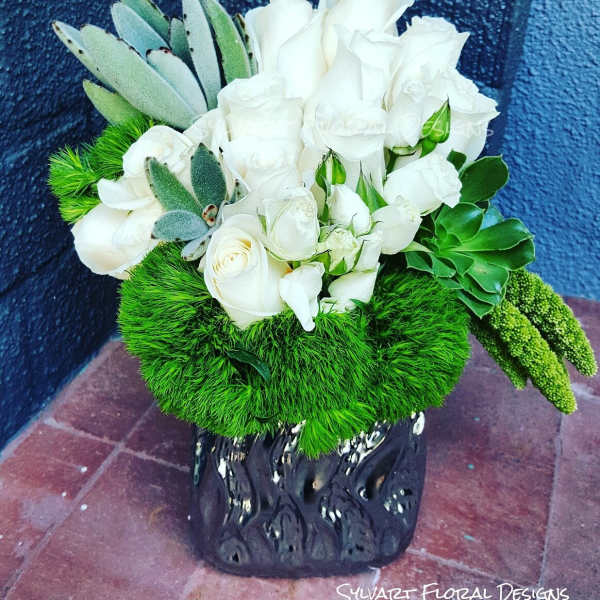 White rose bouquet with green succulents in a black vase