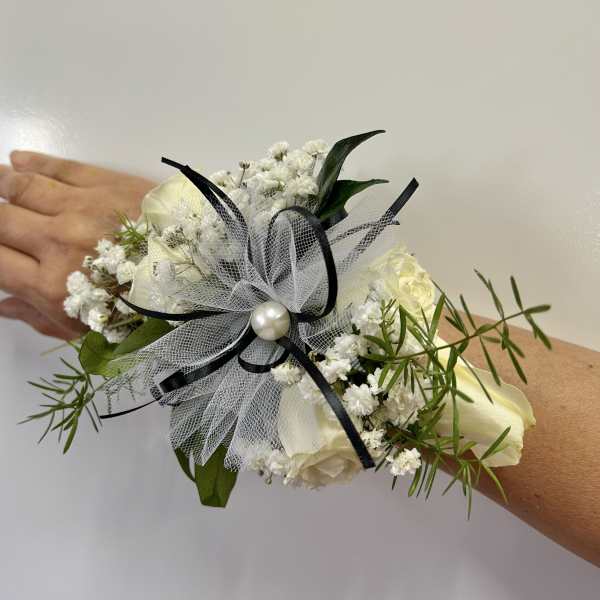 White floral wrist corsage with black ribbon and tulle
