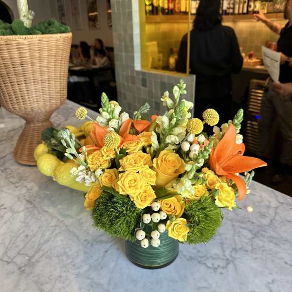 Yellow rose arrangement with orange lilies in a green vase