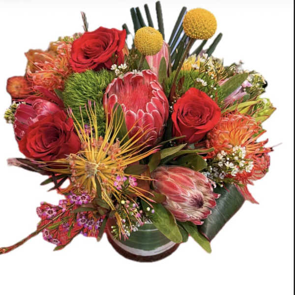 Mixed bouquet with red roses and pink protea in a vase