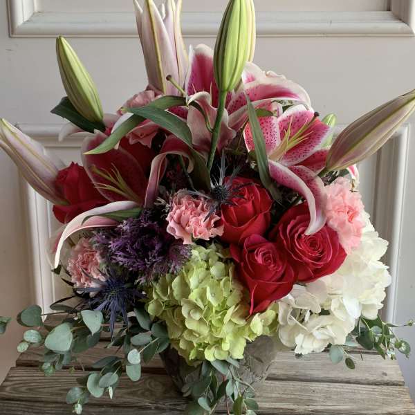 Bouquet of pink lilies, red roses, and hydrangeas with eucalyptus