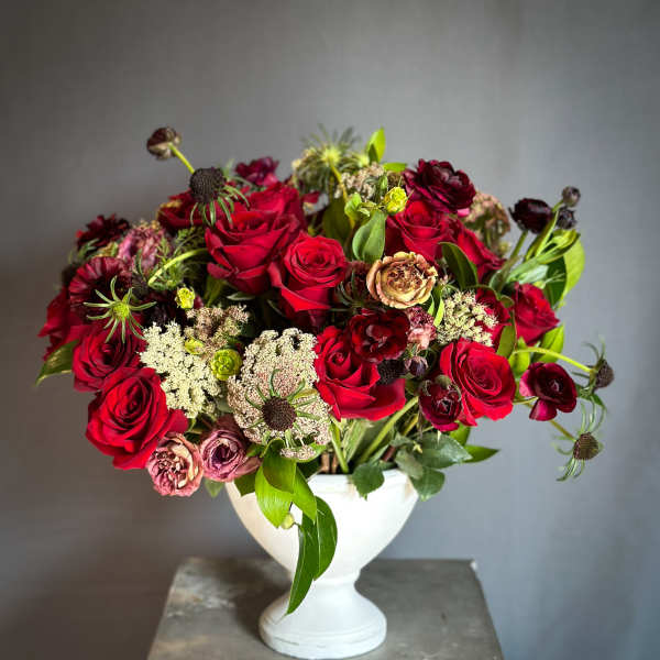 Red rose bouquet in a white pedestal vase