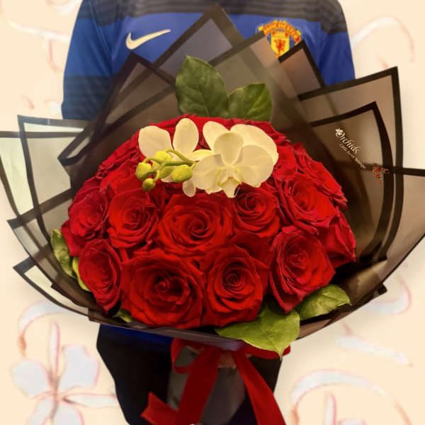 Bouquet of red roses with white orchids wrapped in dark paper