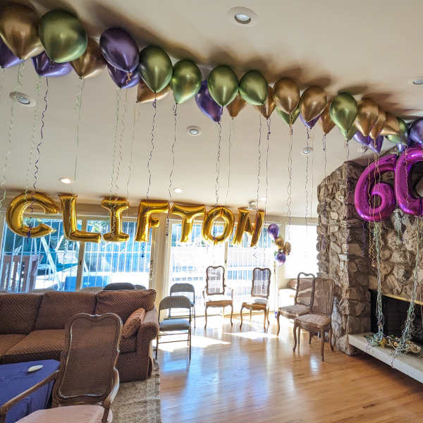 Balloon decorations spelling "CLIFTON" and "60" in a living room