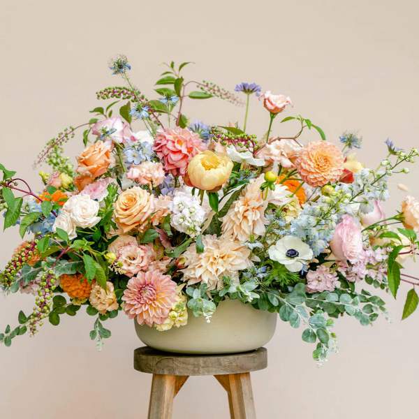 Large pastel floral arrangement in a low white bowl