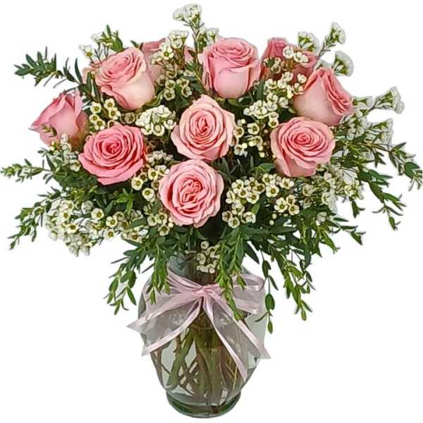 Pink roses in a glass vase with white filler flowers