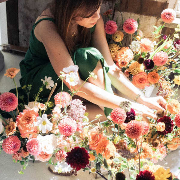 Woman arranging colorful flowers on the floor
