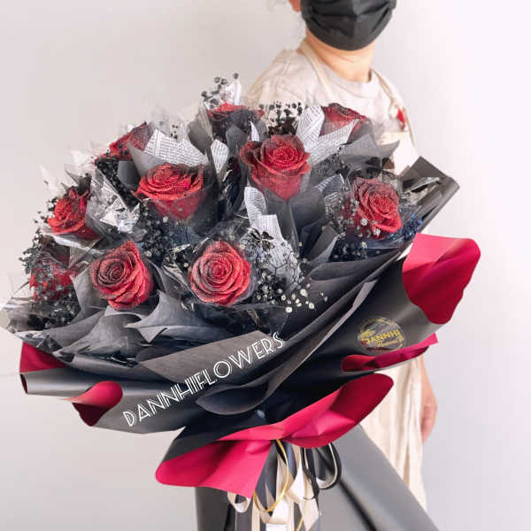 Bouquet of red roses wrapped in black and pink paper