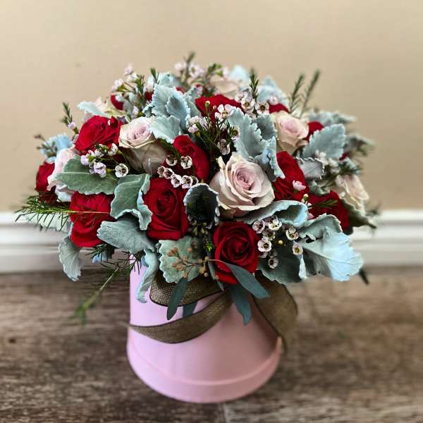 Bouquet of red and pale pink roses in a pink hat box