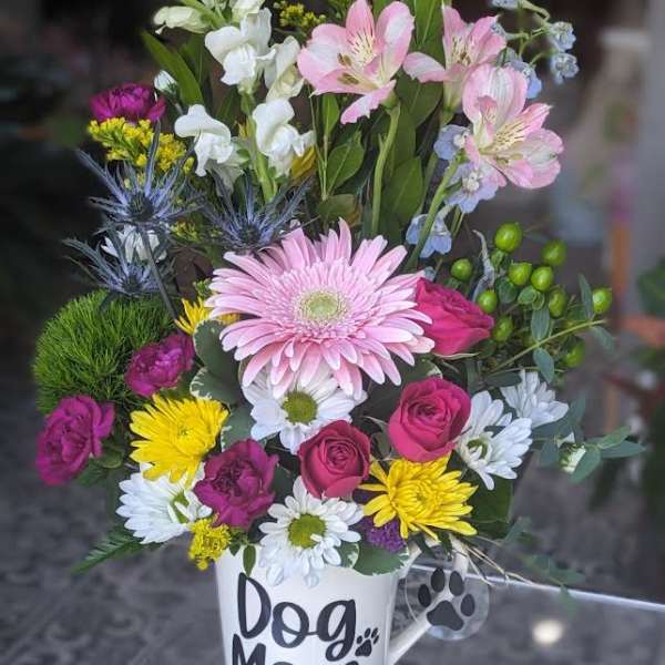Mixed flower arrangement in a white mug labeled Dog Mom