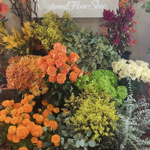 Assorted flower display with roses, chrysanthemums, and tall branches