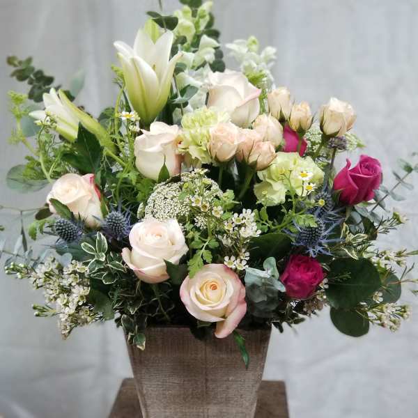 Mixed rose and lily arrangement in a square vase