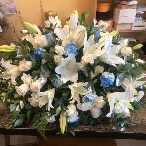 Large white lily and rose arrangement with blue carnations