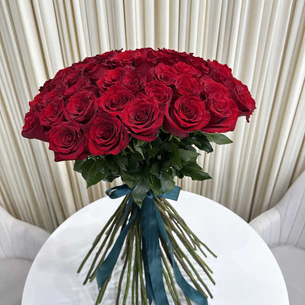 Bouquet of red roses tied with a teal ribbon