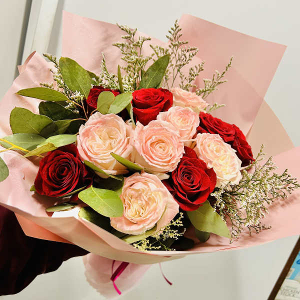 Bouquet of red and blush roses wrapped in pink paper