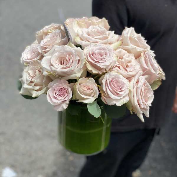 Bouquet of pale pink roses in a green glass vase