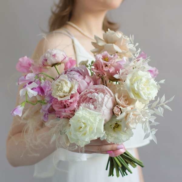 Woman holding a pastel bouquet of pink and white flowers