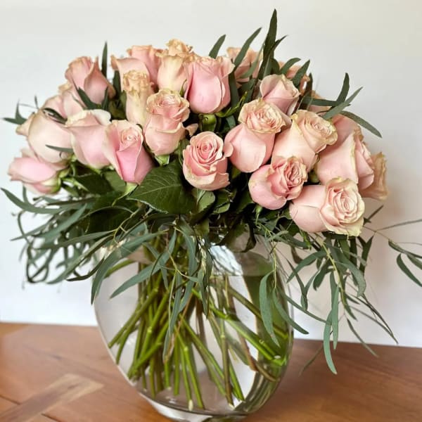 Bouquet of pale pink roses in a clear glass vase