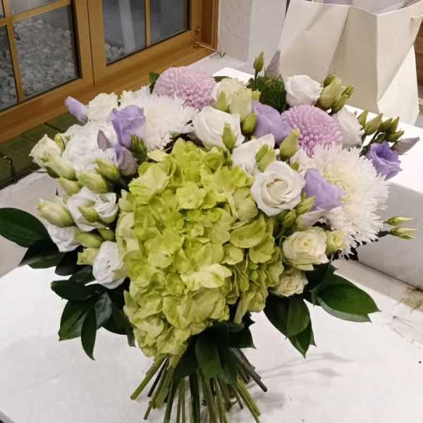Bouquet of green hydrangea, white roses, and lavender flowers
